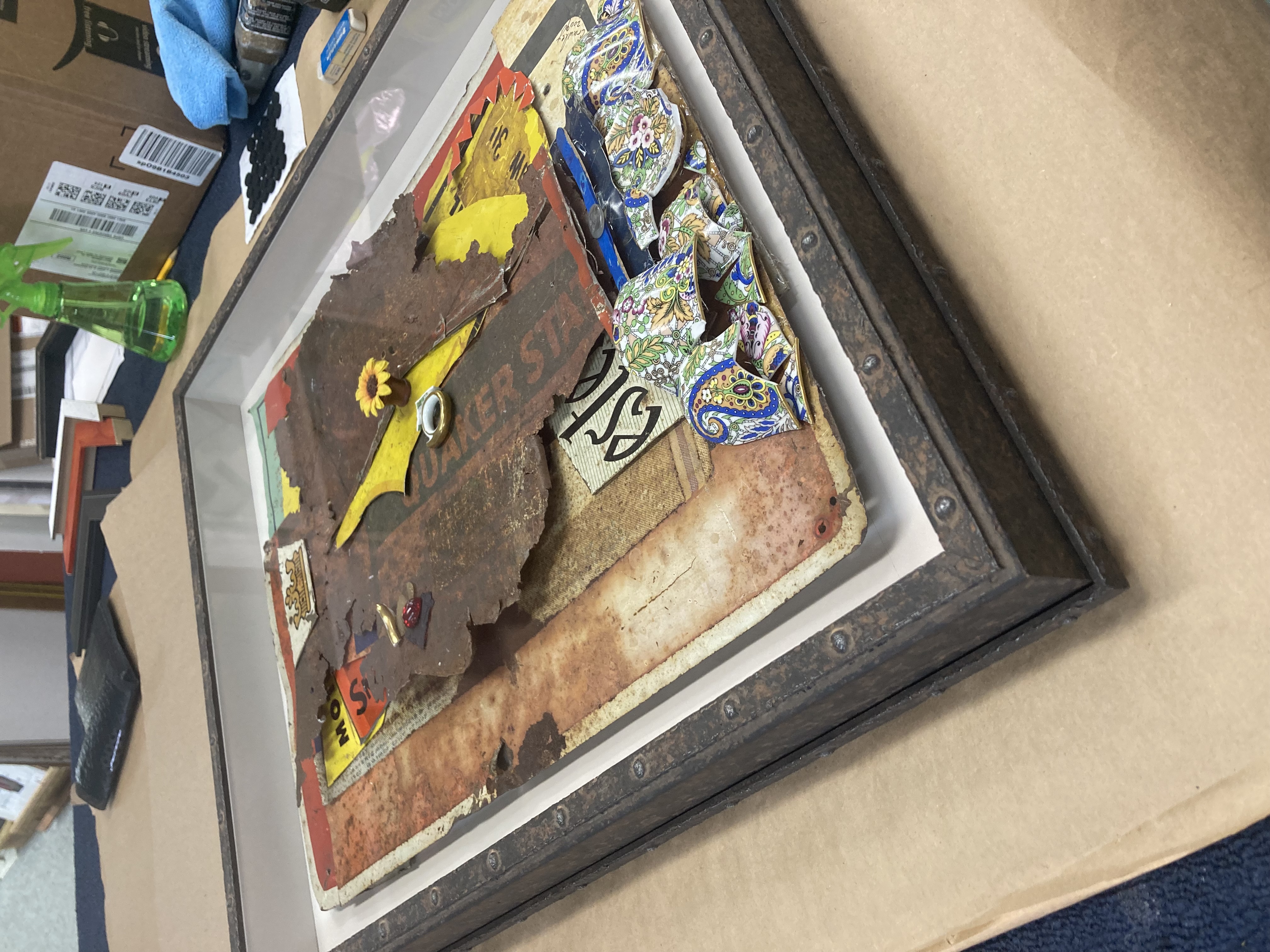 custom framed scrap metal art laying on a workbench